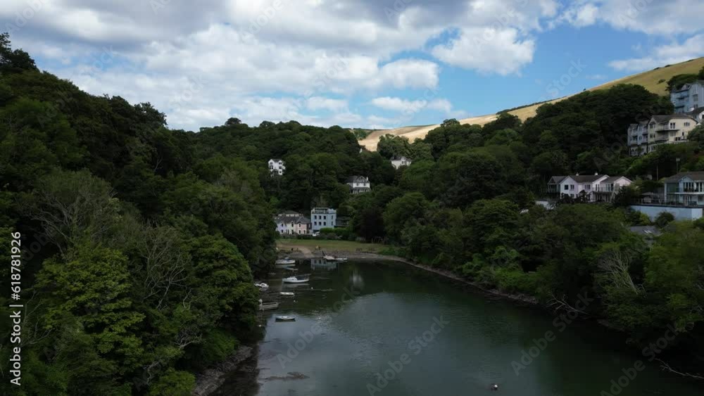 River Dart, Kingswear, South Devon, England: DRONE VIEWS: The drone flies through a heavily wooded, steep-side valley over Waterhead Creek directly towards Jubilee Park and nearby expensive houses. River Dart, Kingswear, South Devon, England: DRONE VIEWS: The drone flies through a heavily wooded, steep-side valley over Waterhead Creek directly towards Jubilee Park and nearby expensive houses.