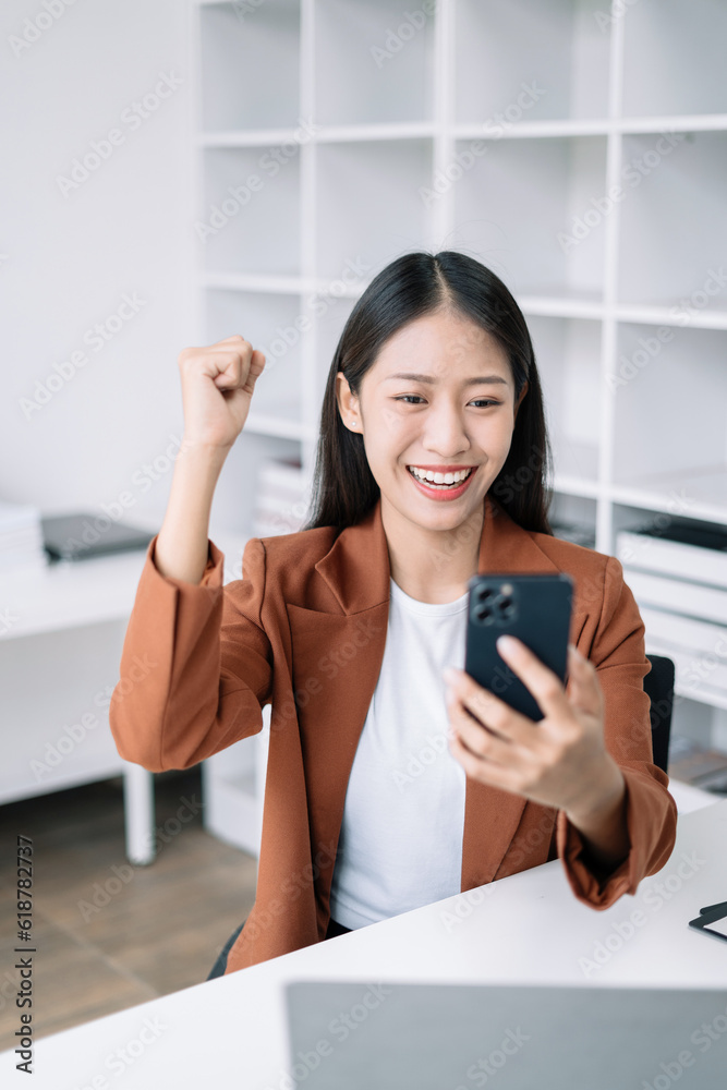 Asian business woman are excited business success with inspiration from their excellent financial results that are happy working in a modern office on a smartphone. Asian business woman are excited business success with inspiration from their excellent financial results that are happy working in a modern office on a smartphone.