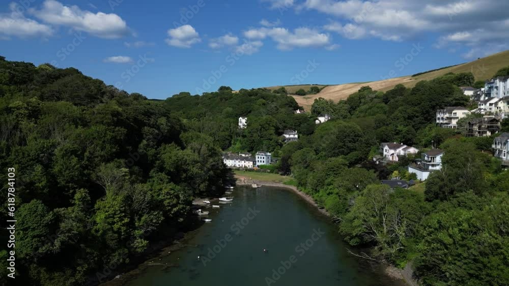 Kingswear, South Devon, England: DRONE VIEWS: The drone flies through a heavily wooded valley, over Waterhead Creek and moored boats, directly towards Jubilee Park and nearby upmarket houses. Kingswear, South Devon, England: DRONE VIEWS: The drone flies through a heavily wooded valley, over Waterhead Creek and moored boats, directly towards Jubilee Park and nearby upmarket houses.
