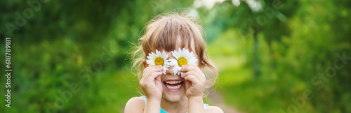 the girl is holding chamomile flowers in her hands. Selective focus.