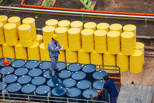 Fotografering Male worker inspection record drum oil stock barrels yellow vertical or chemical