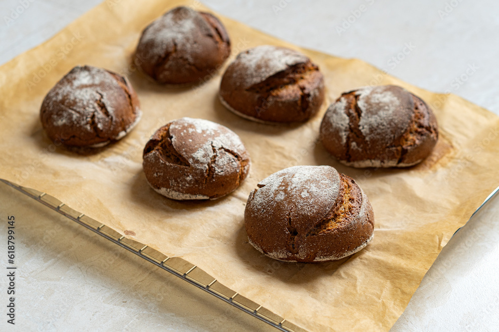 Warm rye buns on baking paper Warm rye buns on baking paper