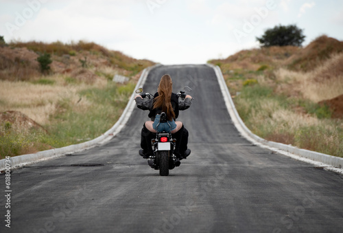 Sexy woman wearing with blonde long hair riding a street motorbike outdoors. Exploration journey adventure, street bike