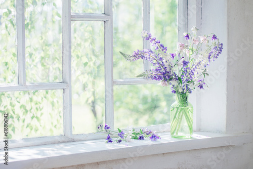 summer flowers in vase on windowsill in sunlight