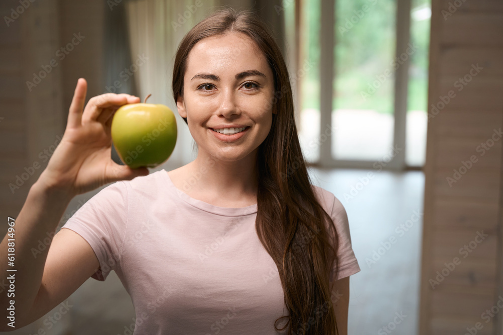 Young woman about to eating green apple at home Young woman about to eating green apple at home