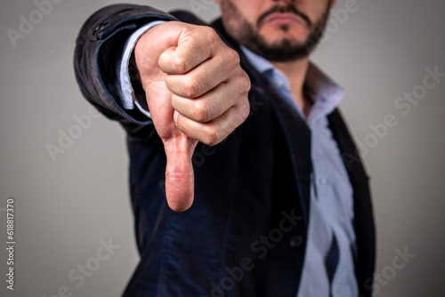 Hombre haciendo pulgar abajo con su mano en señal de desaprobación photo