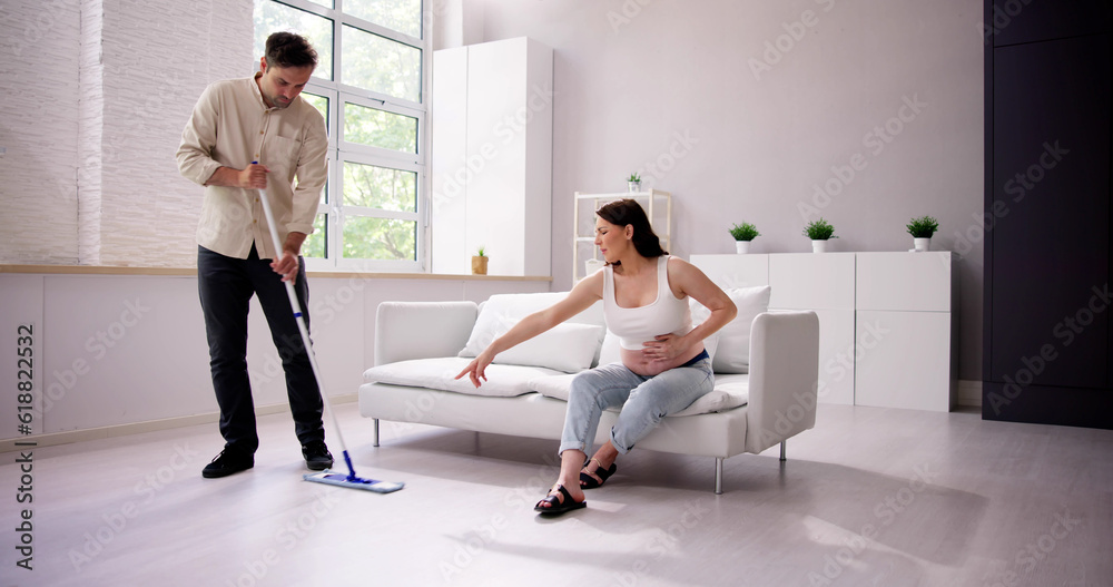 Obraz premium Man Helping Pregnant Wife. Cleaning House