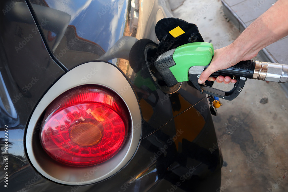 A man refueling his hatchback sport car A man refueling his hatchback sport car