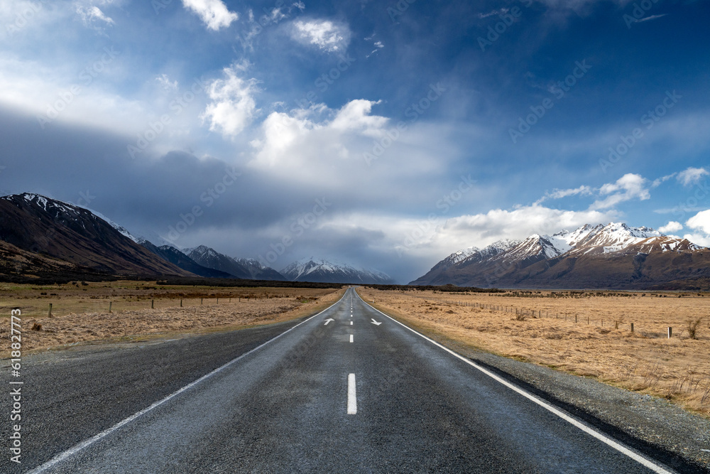 Scenic view along the Mount Cook Road alongside with snow capped Southern Alps basking in the late winter evening light. Best road trip route in New Zealand South Island with majestic Mount Cook. 