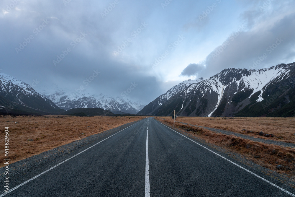 Scenic view along the Mount Cook Road alongside with snow capped Southern Alps basking in the late winter evening light. Best road trip route in New Zealand South Island with majestic Mount Cook. 