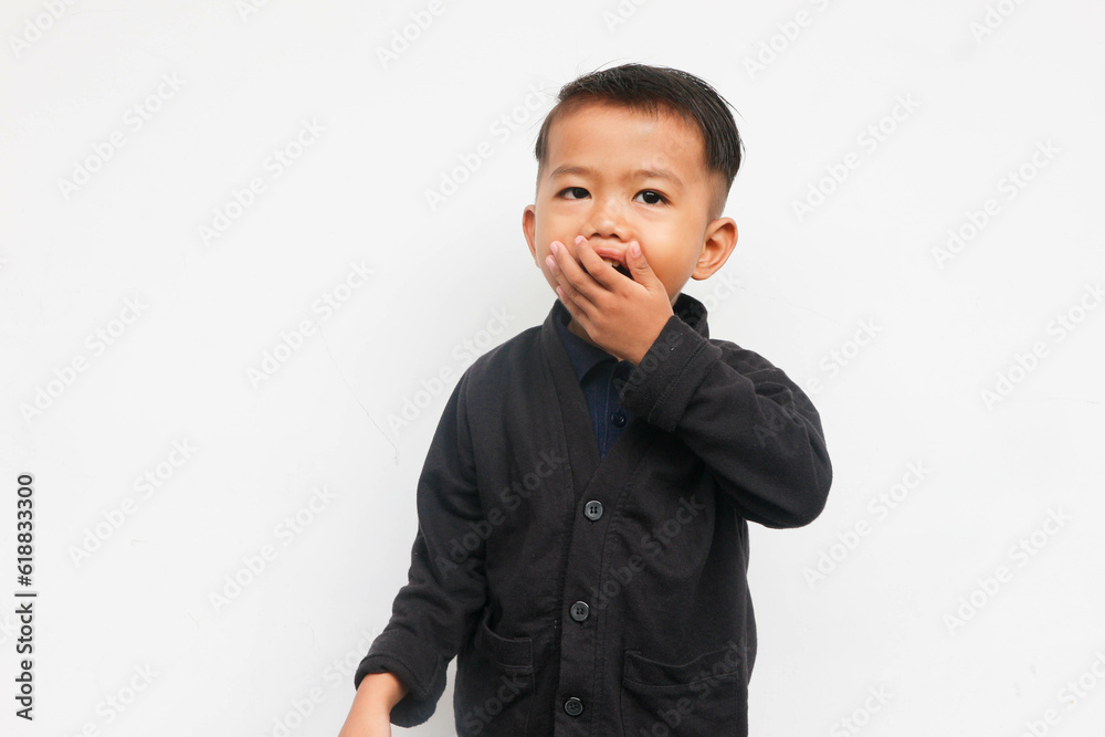 A smiling toddler boy closing his mouth while looks at the camera with confidence, isolated on white background A smiling toddler boy closing his mouth while looks at the camera with confidence, isolated on white background