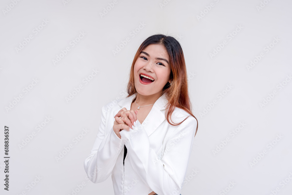 An optimistic young woman with hands clasped together in excitement. Isolated on a white background. An optimistic young woman with hands clasped together in excitement. Isolated on a white background.