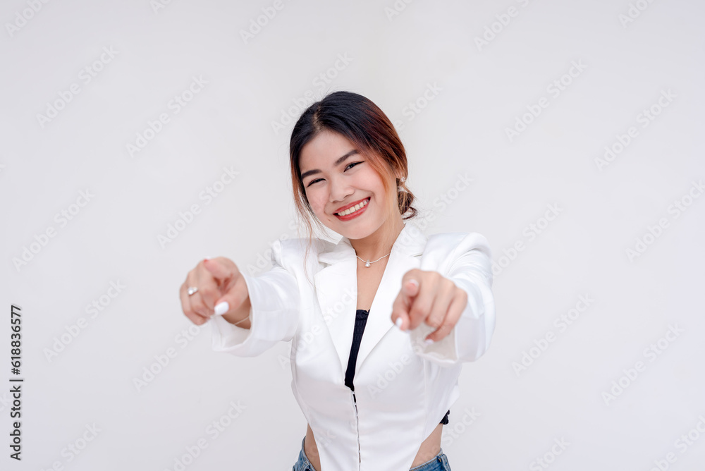 A smiling and cheerful young lady pointing at the camera with both hands. Isolated on a white background. A smiling and cheerful young lady pointing at the camera with both hands. Isolated on a white background.