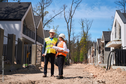 Main construction workers walking along construction site, discussing