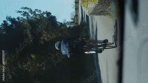 Vertical shot of a lone sportsman cycling on road, cycling sport workout concept