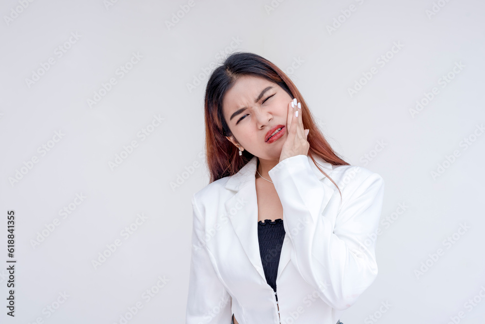 A distressed young woman with severe toothache holding her cheek in agony. Isolated on a white background. A distressed young woman with severe toothache holding her cheek in agony. Isolated on a white background.