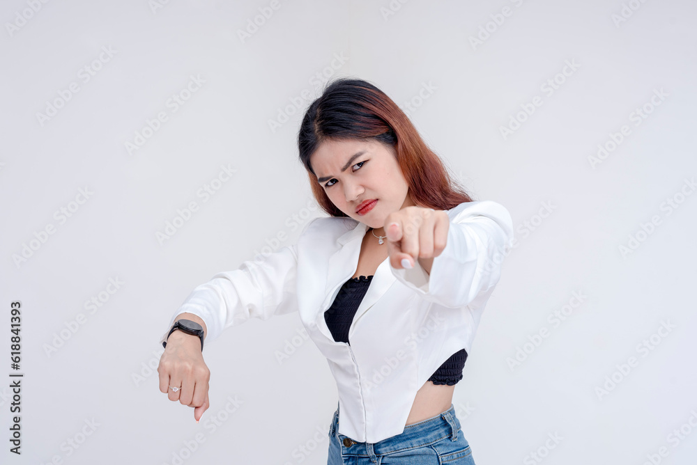 An angry young woman pointing at the camera while showing her watch. Isolated on a white background. An angry young woman pointing at the camera while showing her watch. Isolated on a white background.