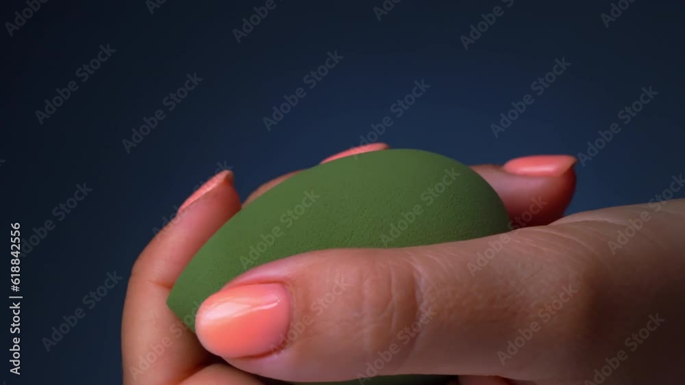 Close up of female hand squeezing makeup sponges, foundation sponge or beauty blending sponge Close up of female hand squeezing makeup sponges, foundation sponge or beauty blending sponge