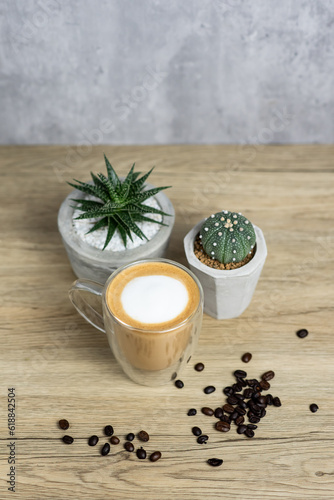 Hot latte with cactus pots on wood table