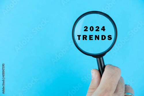 Focused on trend for next year 2024 concept. Words 2024 trends under magnifying glass. Card design. 