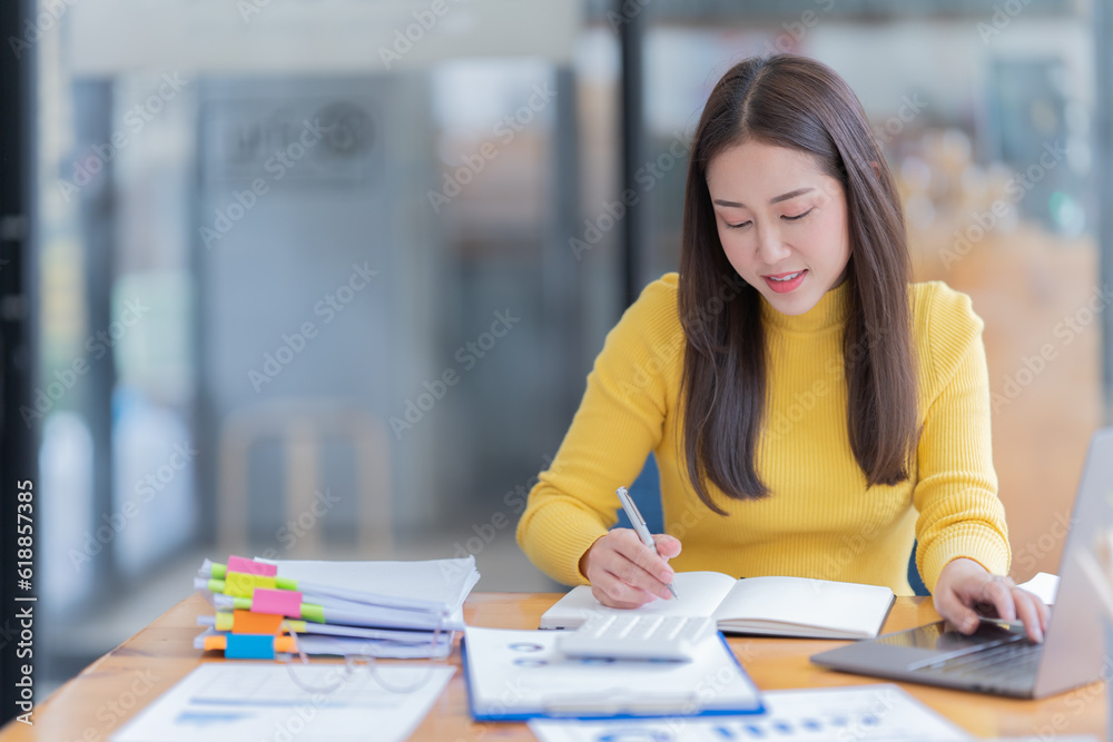 Attractive young office worker holding a binder as she looks at the camera with a sweet friendly smile Attractive young office worker holding a binder as she looks at the camera with a sweet friendly smile
