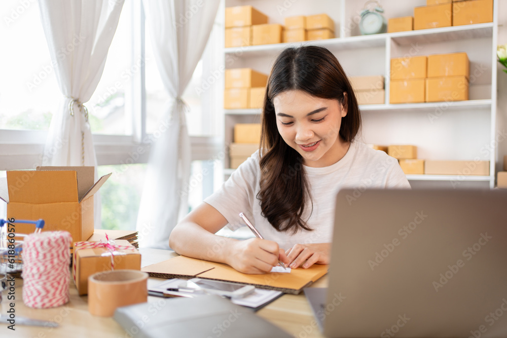 Woman Writing Customer Details for Shipping in Home Office, Packing Box and Writing Customer Information for Efficient Shipping, E-Commerce and Online Selling Concept. Woman Writing Customer Details for Shipping in Home Office, Packing Box and Writing Customer Information for Efficient Shipping, E-Commerce and Online Selling Concept.