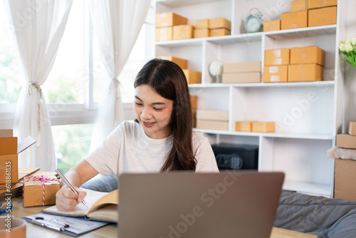 Woman Writing Customer Details for Shipping in Home Office, Packing Box and Writing Customer Information for Efficient Shipping, E-Commerce and Online Selling Concept. © Puwasit Inyavileart