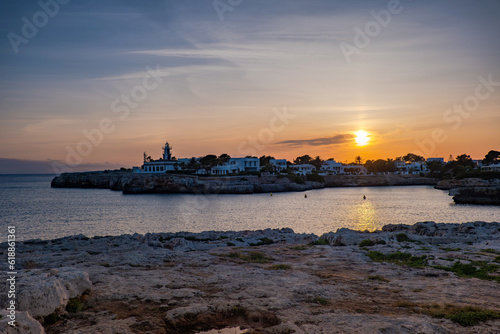 Landscape view of Cala Santandria with lighthouse at sunset Menorca, Spain. © DOUGLAS