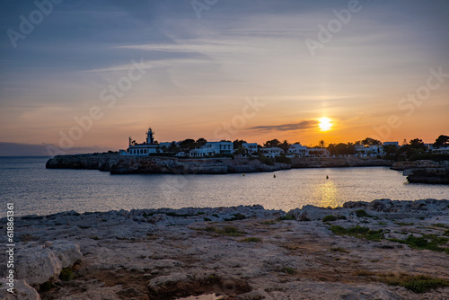 Obraz na płótnie Landscape view of Cala Santandria with lighthouse at sunset Menorca, Spain. w salonie