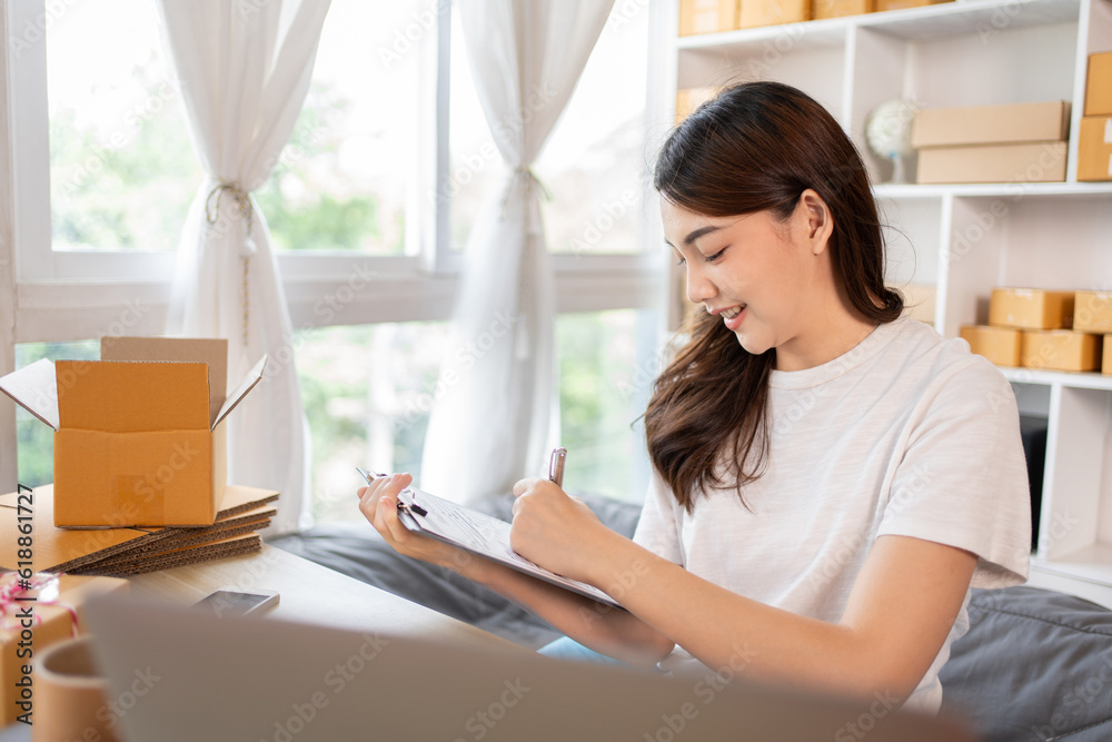 Woman Writing Customer Details for Shipping in Home Office, Packing Box and Writing Customer Information for Efficient Shipping, E-Commerce and Online Selling Concept. Woman Writing Customer Details for Shipping in Home Office, Packing Box and Writing Customer Information for Efficient Shipping, E-Commerce and Online Selling Concept.