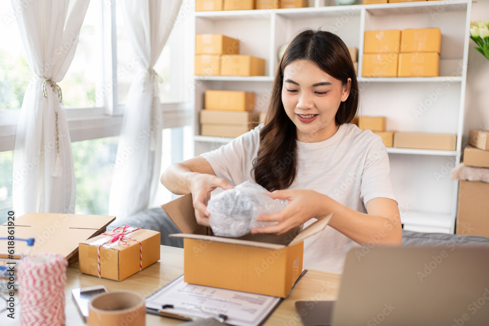 Efficient Home-Based Delivery, Woman Packing Items into Post Box for Customer Shipping, Online Shopping and Small Business Entrepreneurship, Packing box, Sell online, Freelance working. Efficient Home-Based Delivery, Woman Packing Items into Post Box for Customer Shipping, Online Shopping and Small Business Entrepreneurship, Packing box, Sell online, Freelance working.