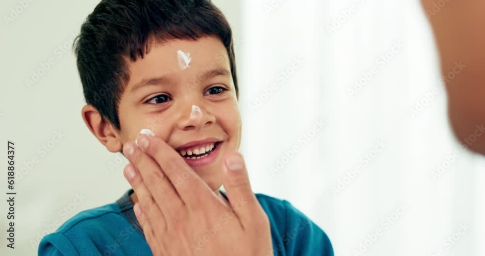 Young boy, skincare and lotion with a smile from morning hygiene and cream. Laugh, kid and moisturizer with youth in a family home and bathroom with sunscreen and facial care and clean cosmetics