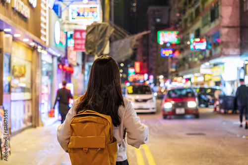Young woman traveler walking in the Mong Kok night market in Hong Kong