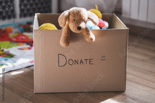 Leinwand Poster Donation cardboard box with childrens clothes and toys, charity and volunteering