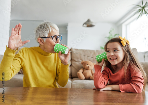 grandchild family child grandparent grandmother game playing granddaughter phone toy communication connection call string talk cup telephone voice message technology sound listen wire girl hobby photo
