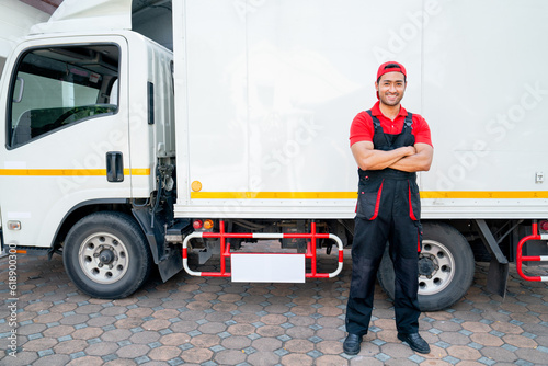 Portrait of Asian delivery man stand beside of truck and arm-crossed also look at camera with smiling after finish to send the product to customer house. © narong