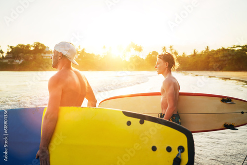 Photography Young teen boy with a surfboard with his father go to the sea for surfing