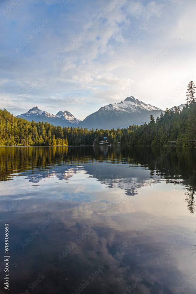 sunrise over a calm lake with mountains and forest landscape