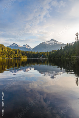 Fototapeta Naklejka Na Ścianę i Meble -  sunrise over a calm lake with mountains and forest landscape