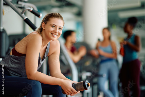 Happy athletic woman during sports training in gym looking at camera.