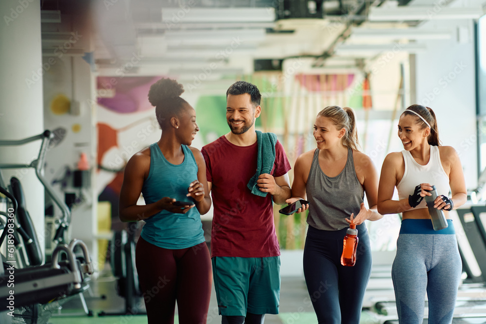 Multiracial group of happy friends talk after exercising in gym. Multiracial group of happy friends talk after exercising in gym.