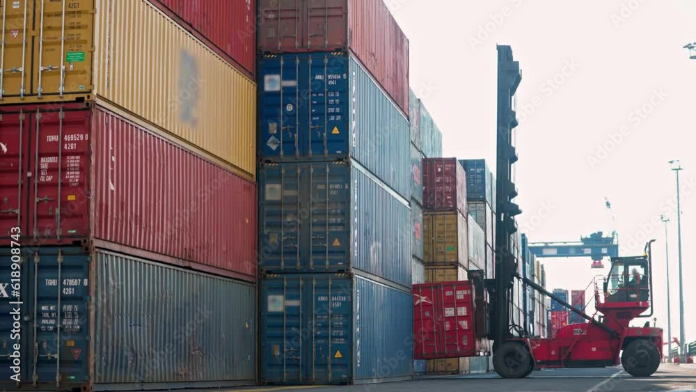 4K footage of forklift bringing down container. Colorful shipping containers stacked at port stock video.