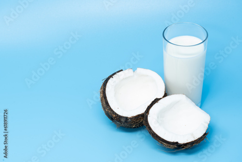 coconut split in half with glass of coconut milk