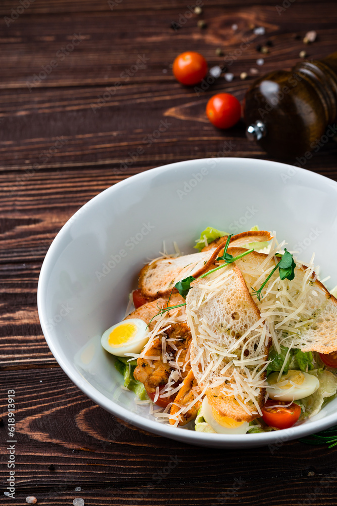 Caesar salad with chicken, parmesan cheese, eggs, lettuce, tomatoes and croutons, Italian cuisine. Caesar salad with chicken, parmesan cheese, eggs, lettuce, tomatoes and croutons, Italian cuisine.