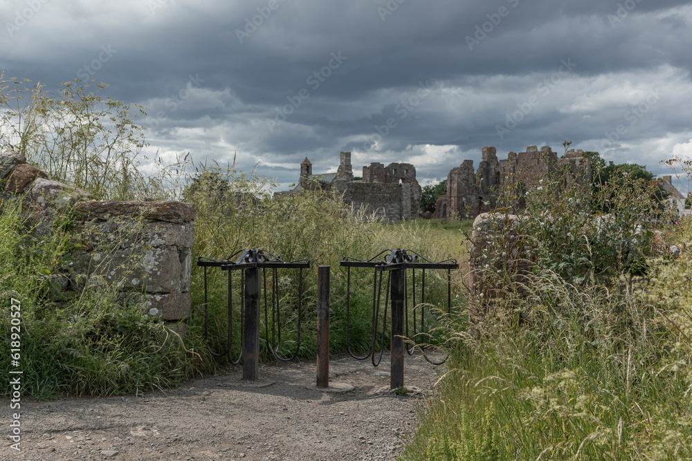 Looking through unique retro turnstiles at the ruins of Lindesfarne Priory