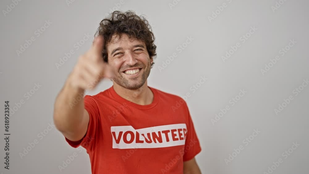Young hispanic man activist wearing volunteer uniform pointing to camera over isolated white background Young hispanic man activist wearing volunteer uniform pointing to camera over isolated white background