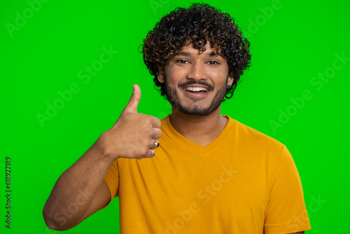 Like. Indian young man in shirt raises thumbs up agrees with something or gives positive reply recommends advertisement likes good. Handsome bearded hindu guy isolated on green chroma key background