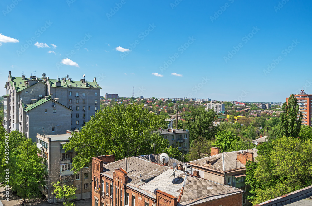 View of roofs of urban highrise buildings and cottages