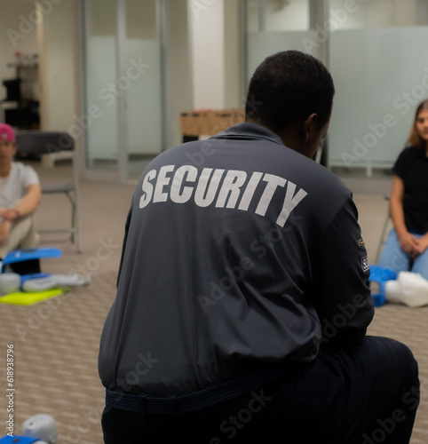 CPR training class by security guard in office