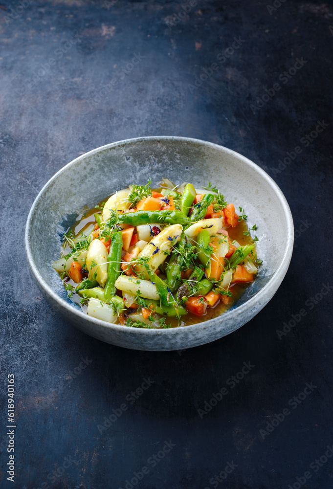 Grüner und weißer Spargel glasiert mit Papaya in süßer Vinaigrette serviert als close-up in einer Design Teller mit Textfreiraum Grüner und weißer Spargel glasiert mit Papaya in süßer Vinaigrette serviert als close-up in einer Design Teller mit Textfreiraum